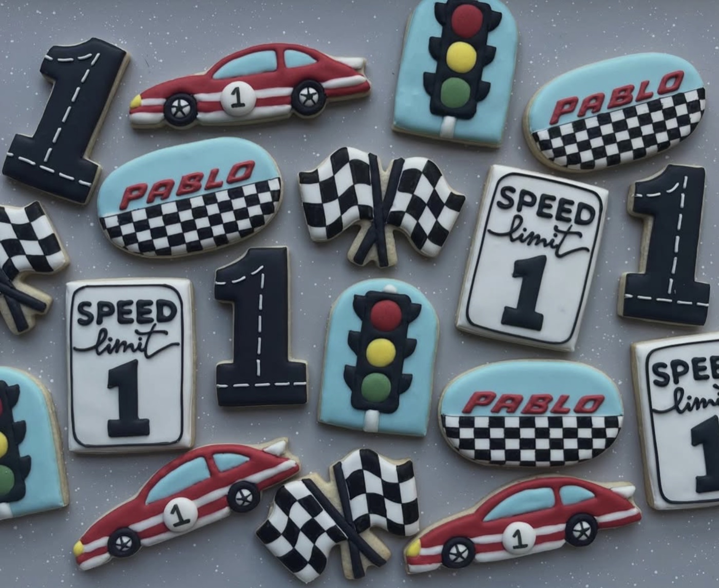 Racing-themed cookies with cars, checkered flags, traffic lights, and number ones
