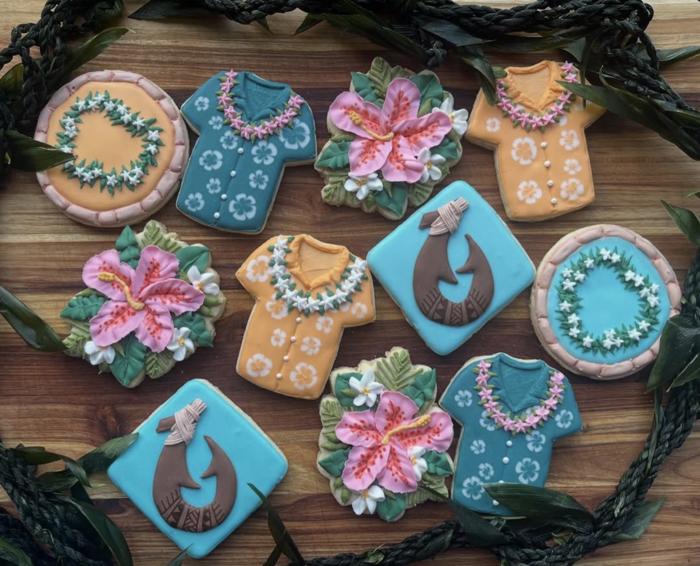 Colorful tropical flower, shirt, and fishhook decorated cookies